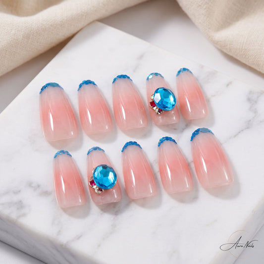 Azure Kiss handmade press-on nails with nude pink colour, blue sequin tips and large azure crystals