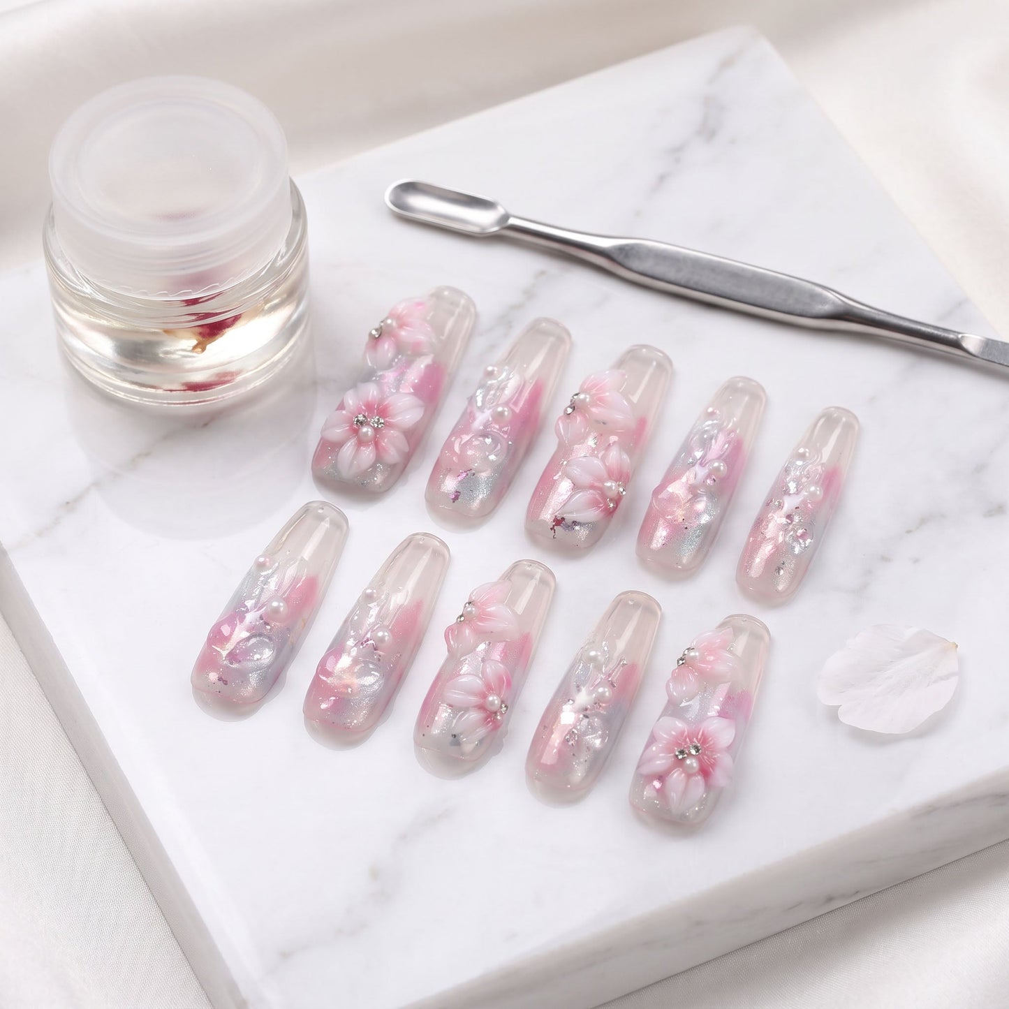 Sakura Kiss press-on nails with translucent pink, sculpted blossom flowers, pearls and silver foil