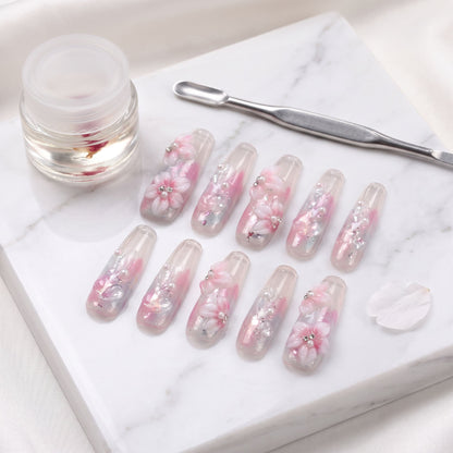 Sakura Kiss press-on nails with translucent pink, sculpted blossom flowers, pearls and silver foil